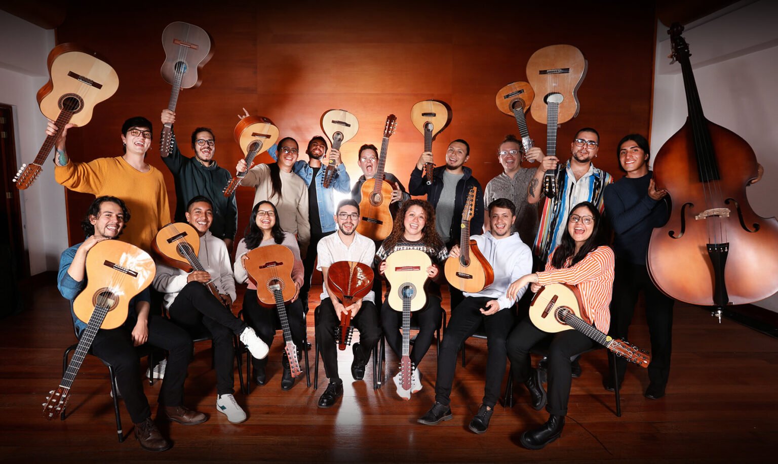 Members of the Filarmónica de Música Colombiana posing with their guitars, tiples, bandolas and double bass