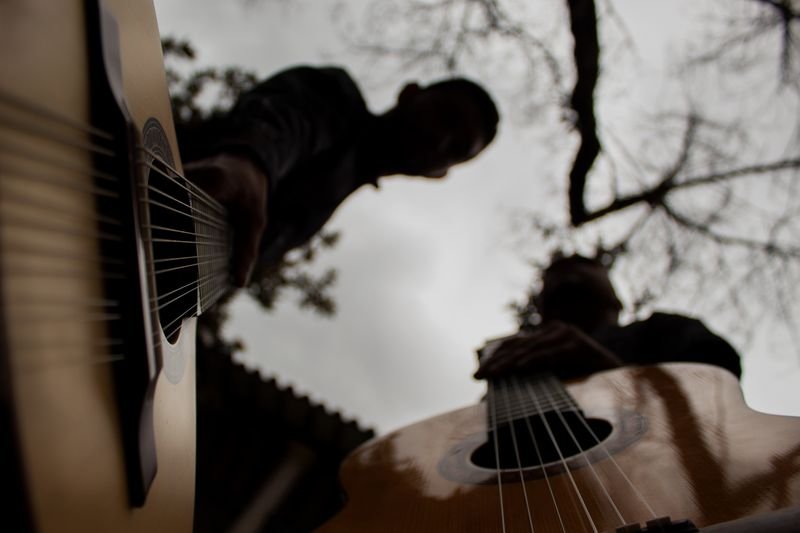 Brayan Ruiz y David Valencia en contrapicado, con la guitarra recortada contra el cielo